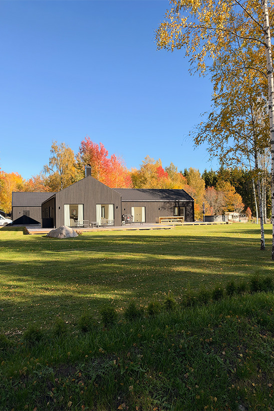 Exteriör av modernt ladhus i Onslunda, Uppsala med altan och stora fönsterpartier.